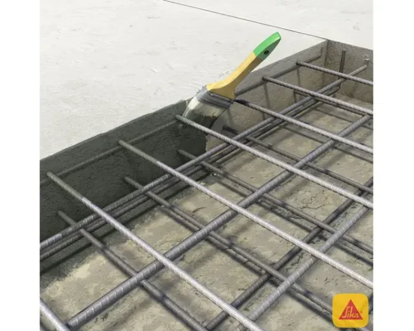 Brocha aplicando Sikadur 32 Gel de Sika en superficie de concreto con armadura metálica, previo a vertido de concreto fresco