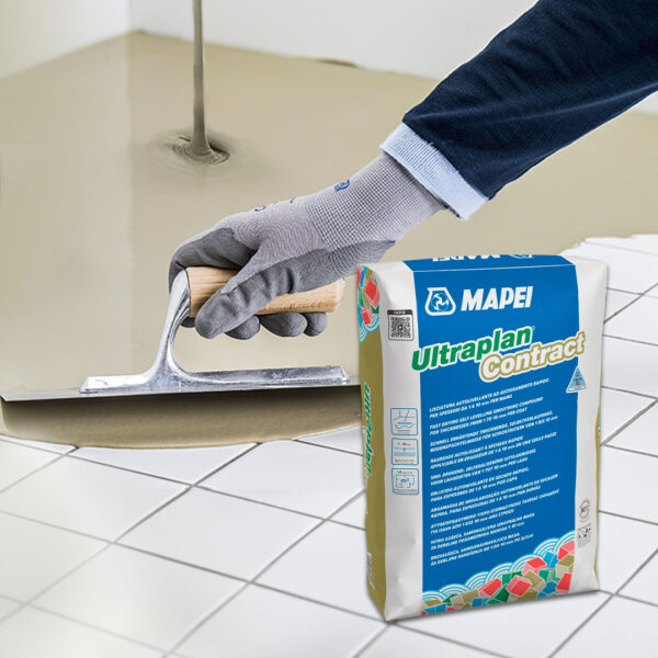 Trabajador aplicando mortero autonivelante Ultraplan Contract 3-40 de Mapei sobre piso de cerámica usando llana manual, junto a saco del producto