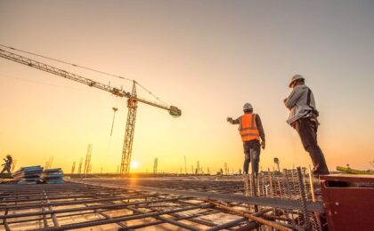 silhouette group of worker and civil engineer  in safety uniform install reinforced steel column in construction site during sunset time industrial concept