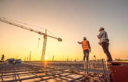 silhouette group of worker and civil engineer  in safety uniform install reinforced steel column in construction site during sunset time industrial concept