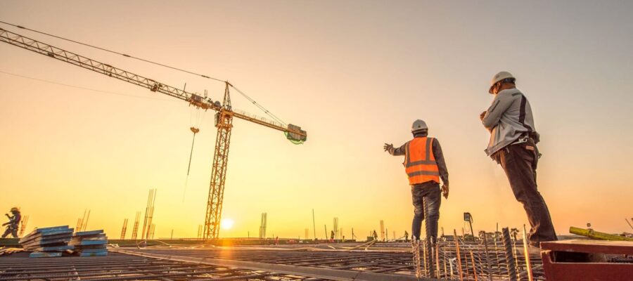 silhouette group of worker and civil engineer  in safety uniform install reinforced steel column in construction site during sunset time industrial concept