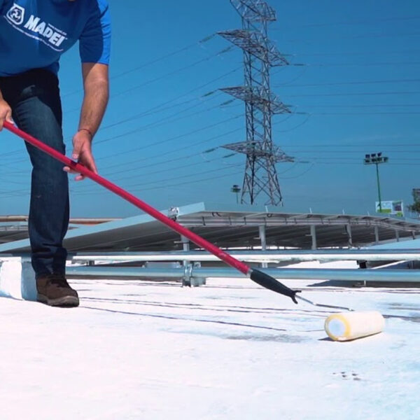 Aplicación de membrana para techo Aquaflex en superficie blanca con rodillo